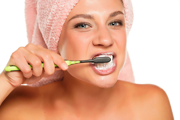 Gyönyörű fiatal nő mosás fogát fehér háttér - Fotó, kép