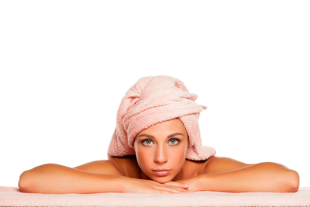 Young serious beautiful woman posing with towel on her head on white background - Foto, afbeelding