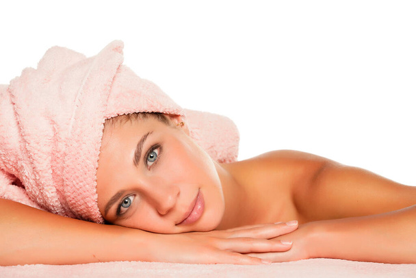 a young beautiful woman with blue eyes posing with a towel on her head on a white background - Photo, image