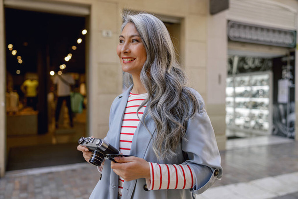 Busy mature lady taking stroll through city - Photo, image