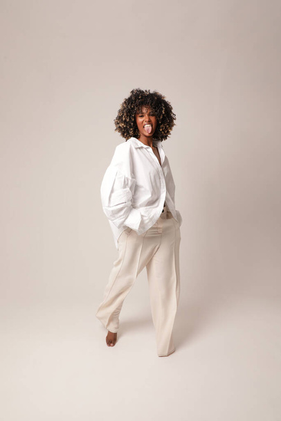 Full-length portrait of beautiful young black woman posing in the white studio.  - Fotó, kép