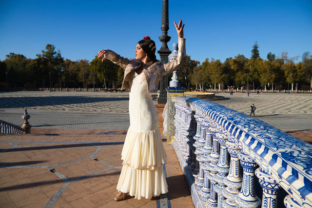 Bailarina de flamenco, mujer, morena y hermosa bailarina típica española está bailando y aplaudiendo en una plaza de Sevilla. Concepto flamenco de patrimonio cultural de la humanidad. - Foto, imagen