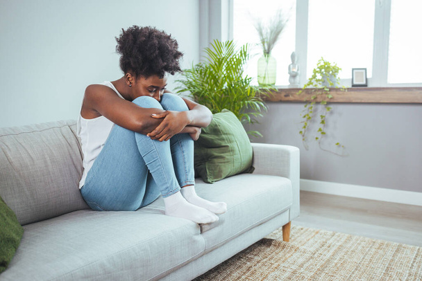 Young attractive African American woman lying at home living room couch feeling sad tired and worried suffering depression in mental health, problems and broken heart concept. - Φωτογραφία, εικόνα