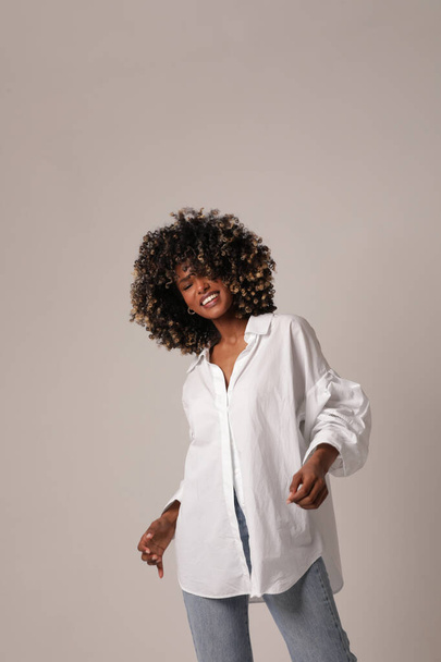 Pretty young black woman posing in the white studio. Vertical photo. - Photo, Image