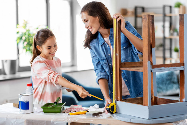 mother and daughter with ruler measuring old table - Foto, imagen