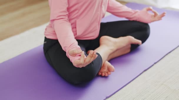 Schöne kaukasische Frau praktiziert Yoga-Meditation in einer Lotusposition zu Hause. - Filmmaterial, Video
