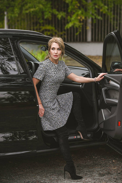 Preciosa mujer con un coche, estilo de lujo, concepto de dama y automóvil - Foto, imagen