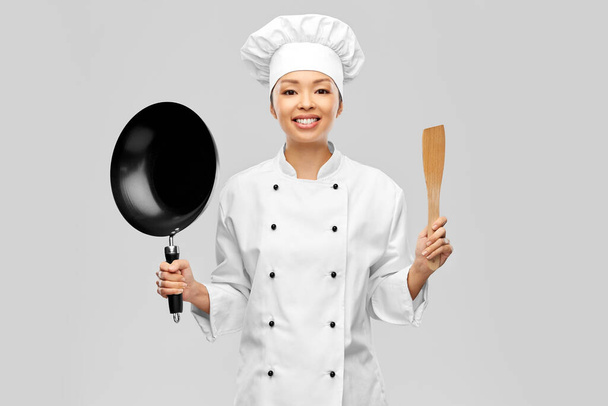 smiling female chef with frying pan and spatula - Foto, imagen