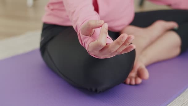 Nahaufnahme Hände einer schönen asiatischen Frau, die zu Hause in einer Lotusposition Yoga praktiziert. - Filmmaterial, Video