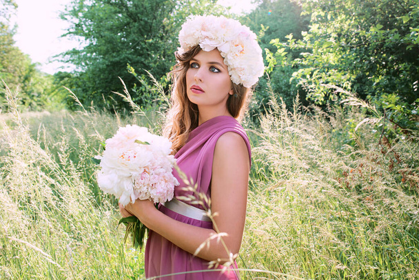 Kaukasische schöne Frau mit einem Kranz aus weißen Pfingstrosen auf dem Kopf. Frühling, Blüte, Märchenkonzept - Foto, Bild