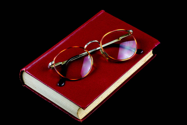 Siyah arka planda eski kitap ve gözlük. - Fotoğraf, Görsel