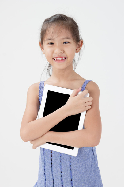 Happy Asian child showing tablet computer - Fotó, kép