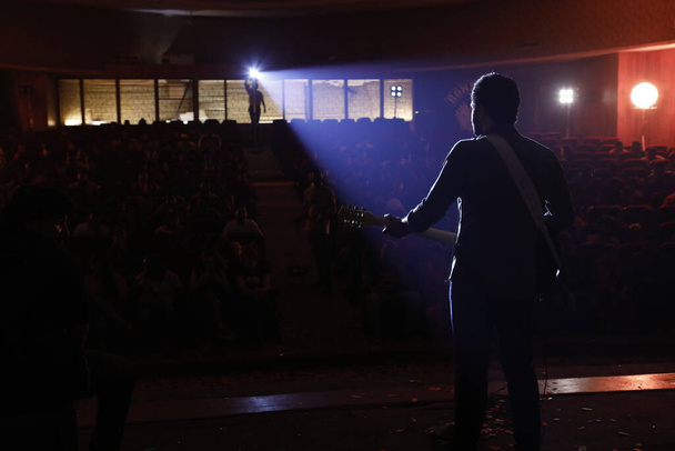 Vue arrièreSilhouette de musicien avec guitare sur scène - Photo, image