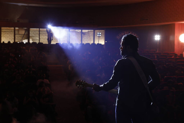 Rear viewSilhouette of Musician with Guitar on the stage - Photo, Image