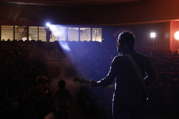 Οπίσθια όψηΣιλουέτα του μουσικού με κιθάρα στη σκηνή - Φωτογραφία, εικόνα