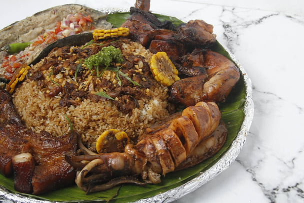何人かの人々の間で共有されることを意図している別の料理で構成されるブードルファイトと呼ばれる新鮮な調理されたフィリピン料理のプレートの写真. - 写真・画像