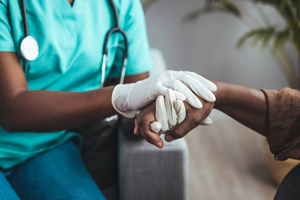 Cropped shot of a female nurse hold her senior patient's hand. Giving Support. Doctor helping old patient with Alzheimer's disease. Female carer holding hands of senior man - Fotó, kép