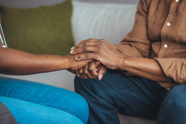 Closeup of a support hands. Closeup shot of a young woman holding a senior man's hands in comfort. Female carer holding hands of senior man  - Photo, Image