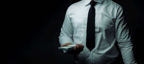 Uomo d'affari in piedi dollaro su sfondo nero con spazio per l'immissione di testo. corruzione, corruzione. - Foto, immagini