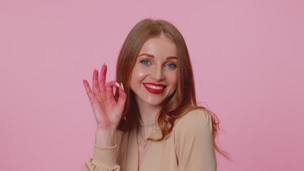 Chica de negocios positiva mostrando buen gesto, como signo positivo algo bueno sobre fondo rosa - Metraje, vídeo