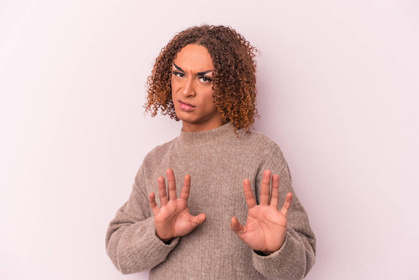 Young latin transsexual woman isolated on pink background rejecting someone showing a gesture of disgust. - Photo, Image