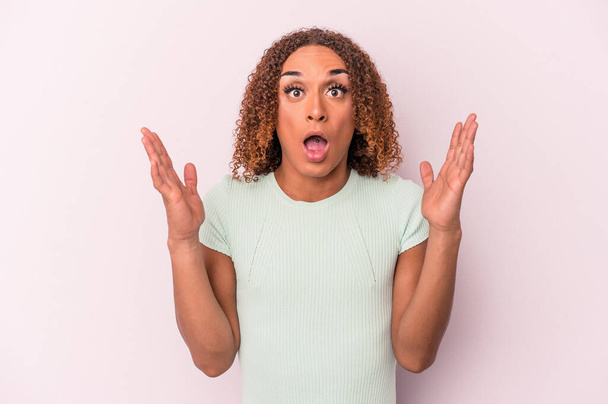 Young latin transsexual woman isolated on pink background celebrating a victory or success, he is surprised and shocked. - Photo, image