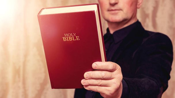 Egy ember imádkozik Bibliával a kezében. - Fotó, kép