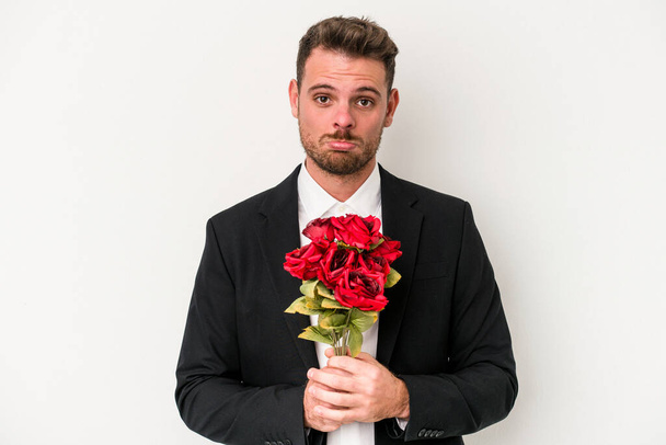 Young caucasian man holding bouquet of flowers isolated on white background - Photo, Image