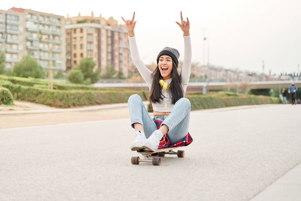 joven latina disfrutando mientras monta un monopatín. chica hispana pasando su tiempo libre haciendo deportes al aire libre. - Foto, Imagen
