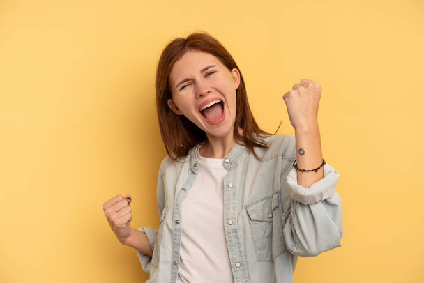 Young English woman isolated on yellow background cheering carefree and excited. Victory concept. - Foto, immagini