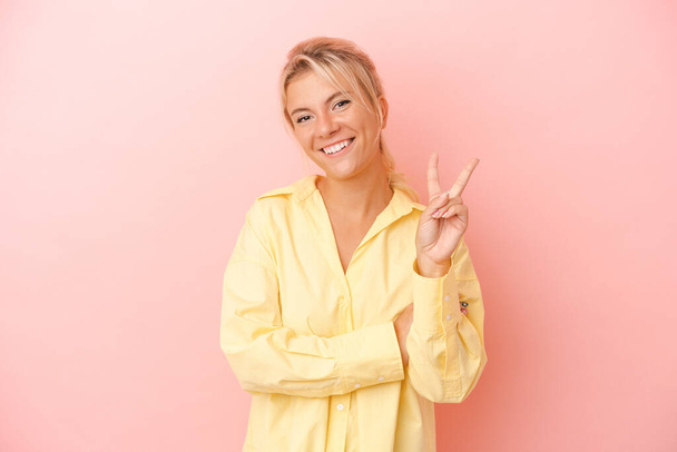 Giovane donna russa isolata su sfondo rosa mostrando il numero due con le dita. - Foto, immagini