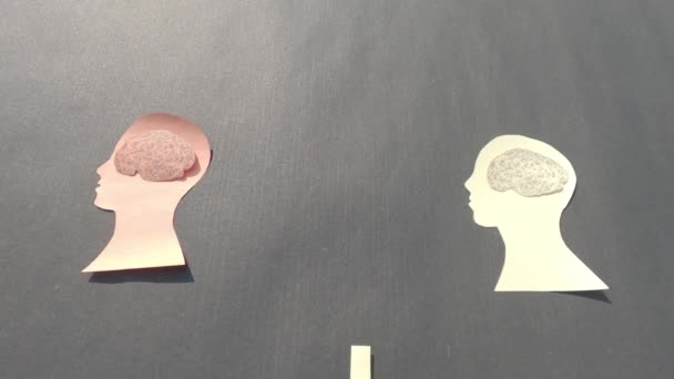 Menselijke hand isoleren van twee afzonderlijke mensen menselijk brein in het menselijk hoofd. Papier Illustratie. Gevoelens van isolatie en concepten van geestelijke gezondheid. - Video