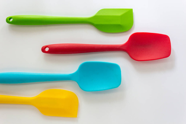Szilikon spatulák különböző színű, piros, kék, zöld és sárga feküdt fehér háttér - Fotó, kép