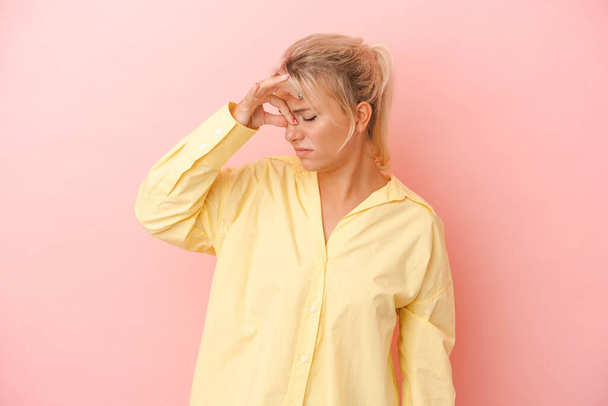 Young Russian woman isolated on pink background having a head ache, touching front of the face. - Photo, Image