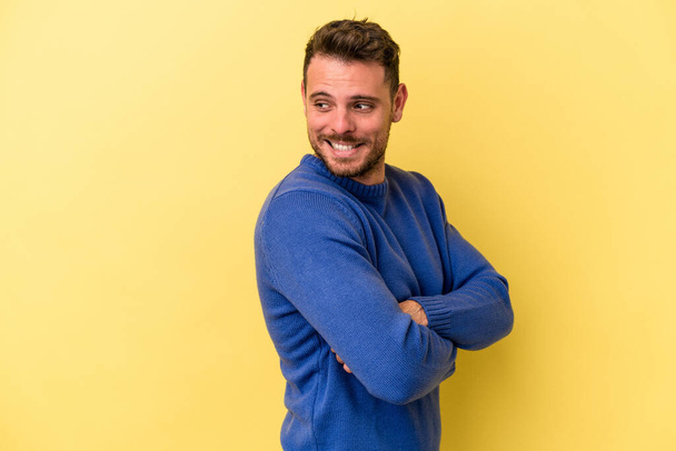 Young caucasian man isolated on yellow background laughing and having fun. - Photo, Image