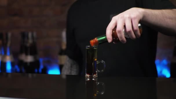 Barman est un jeune homme Le gars verse des boissons, prépare des coups alcooliques seiche noire dans le bar - Séquence, vidéo