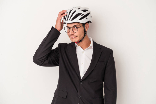 Jeune homme d'affaires caucasien tenant casque de vélo isolé sur fond blanc étant choquée, elle s'est souvenue réunion importante. - Photo, image