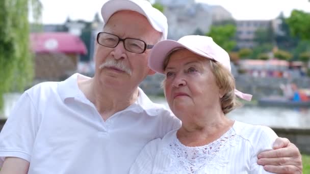 Casal aposentado sentado em um banco de parque, abraçando firmemente. Os avós são relaxantes - Filmagem, Vídeo