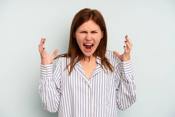 Mladá anglická žena izolované na modrém pozadí křičí vzteky. - Fotografie, Obrázek