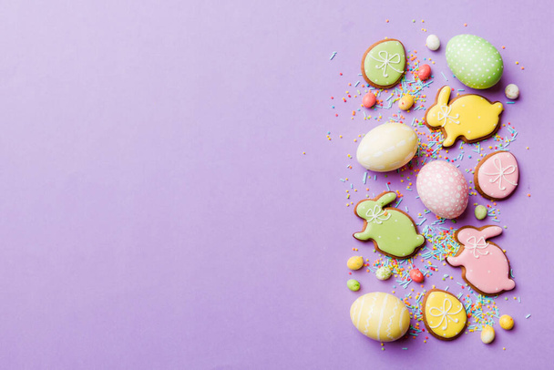 dovolená příprava Multi barvy Velikonoční vejce s cookies na barevném pozadí. Pastelová barva Velikonoční vejce. dovolená koncept s kopírovacím prostorem. - Fotografie, Obrázek