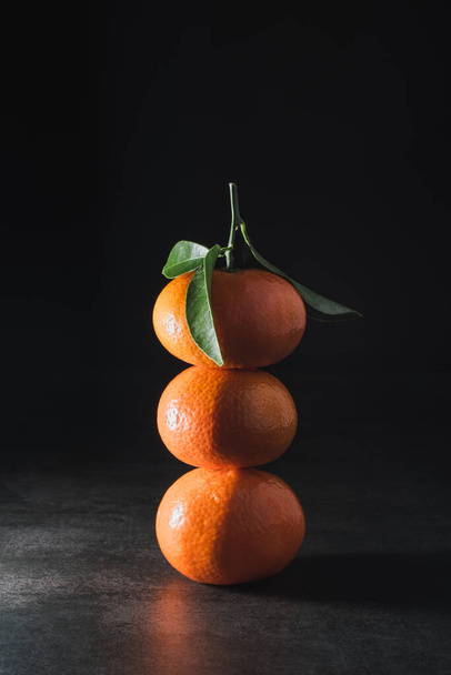 Mandarino fresco con foglie su sfondo scuro - Foto, immagini
