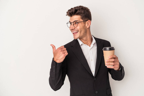 młody biznes biały mężczyzna gospodarstwa zabrać kawę odizolowane na białym tle punkty z kciukiem palec daleko, śmiech i beztroski. - Zdjęcie, obraz