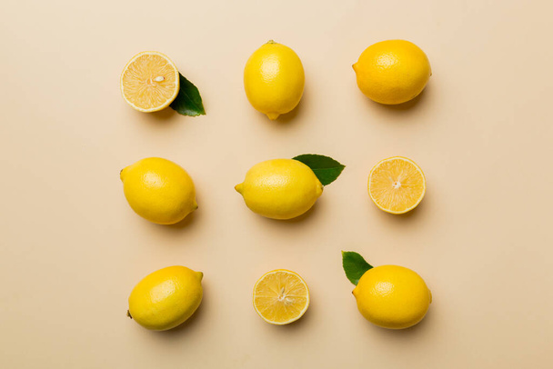 Molti limoni freschi maturi come sfondo colorato, vista dall'alto. Elegante sfondo di fette di limone e limone Vista dall'alto piatto lay. - Foto, immagini
