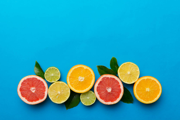 Fruit background. Colorful fresh fruits on colored table. Orange, lemon, grapefruit Space for text healthy concept. Flat lay, top view, copy space. - Fotoğraf, Görsel