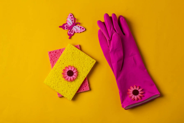 Rubber gloves and sponges waiting for washing on a yellow background. - Photo, Image