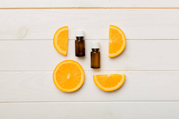 Botellas con aceite esencial de naranja sobre fondo de madera. vista superior de medicina alternativa con espacio de copia. - Foto, imagen