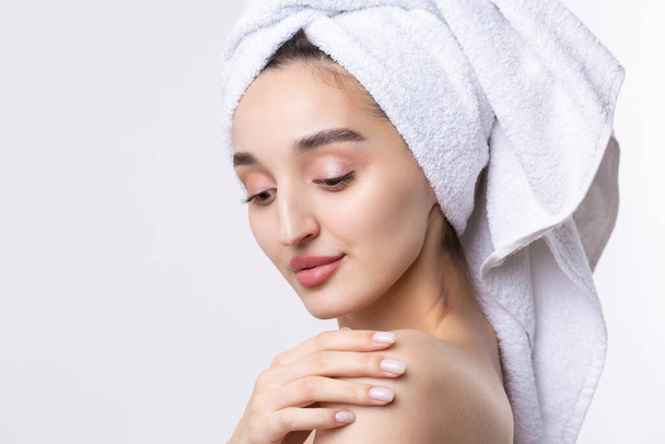 Beautiful girl with thick eyebrows and perfect skin at white background, towel on head, beauty photo. - Foto, immagini