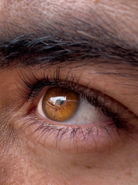 Hehkuva ruskea miehen silmä puhtaalla valkoihoisella iholla - Valokuva, kuva
