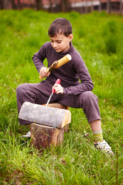 Boy sculpting in a log with a chisel - Foto, Imagem