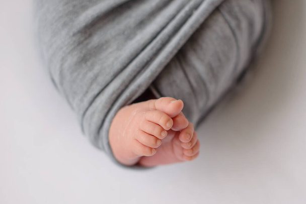 Small beautiful legs of a newborn baby in the first days of life. Baby feet of a newborn - Fotó, kép